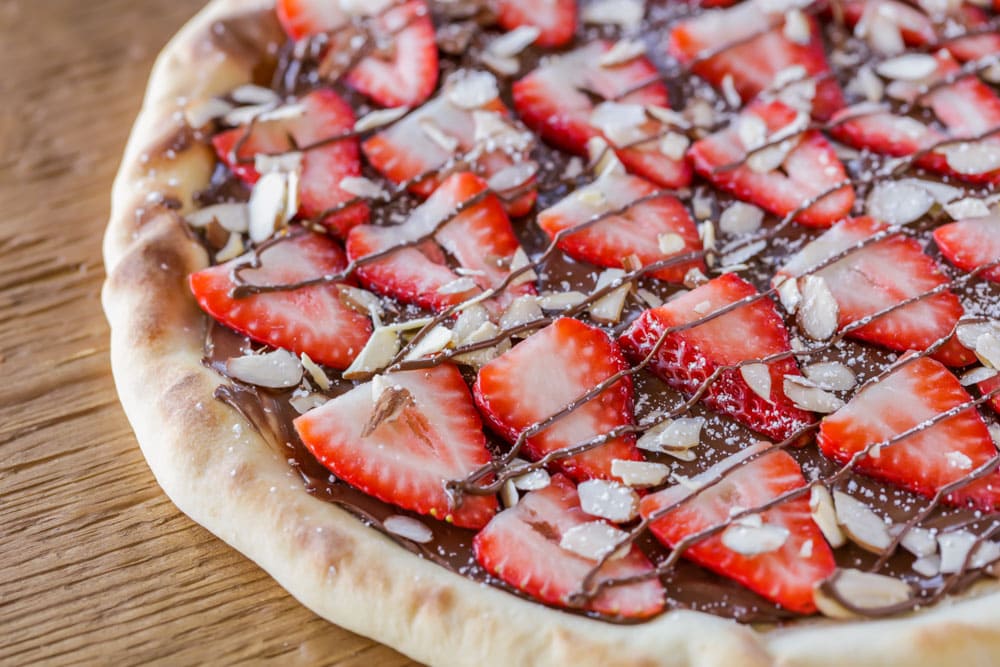 New years eve desserts - close up of strawberry nutella pizza drizzled with nutella.