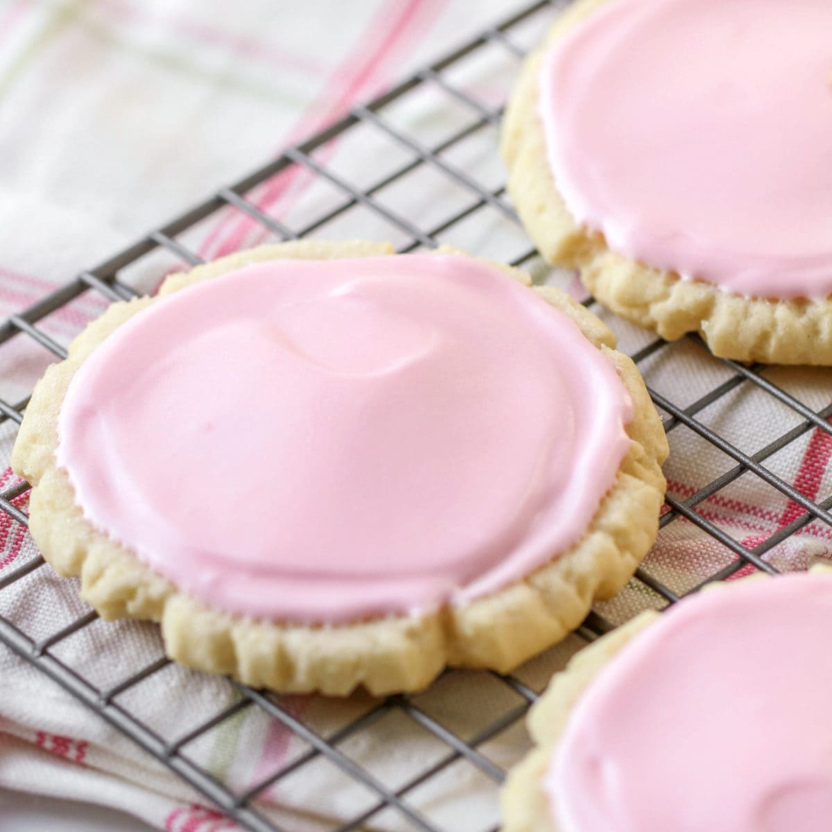 Swig Cookies with pink frosting on a wire rack