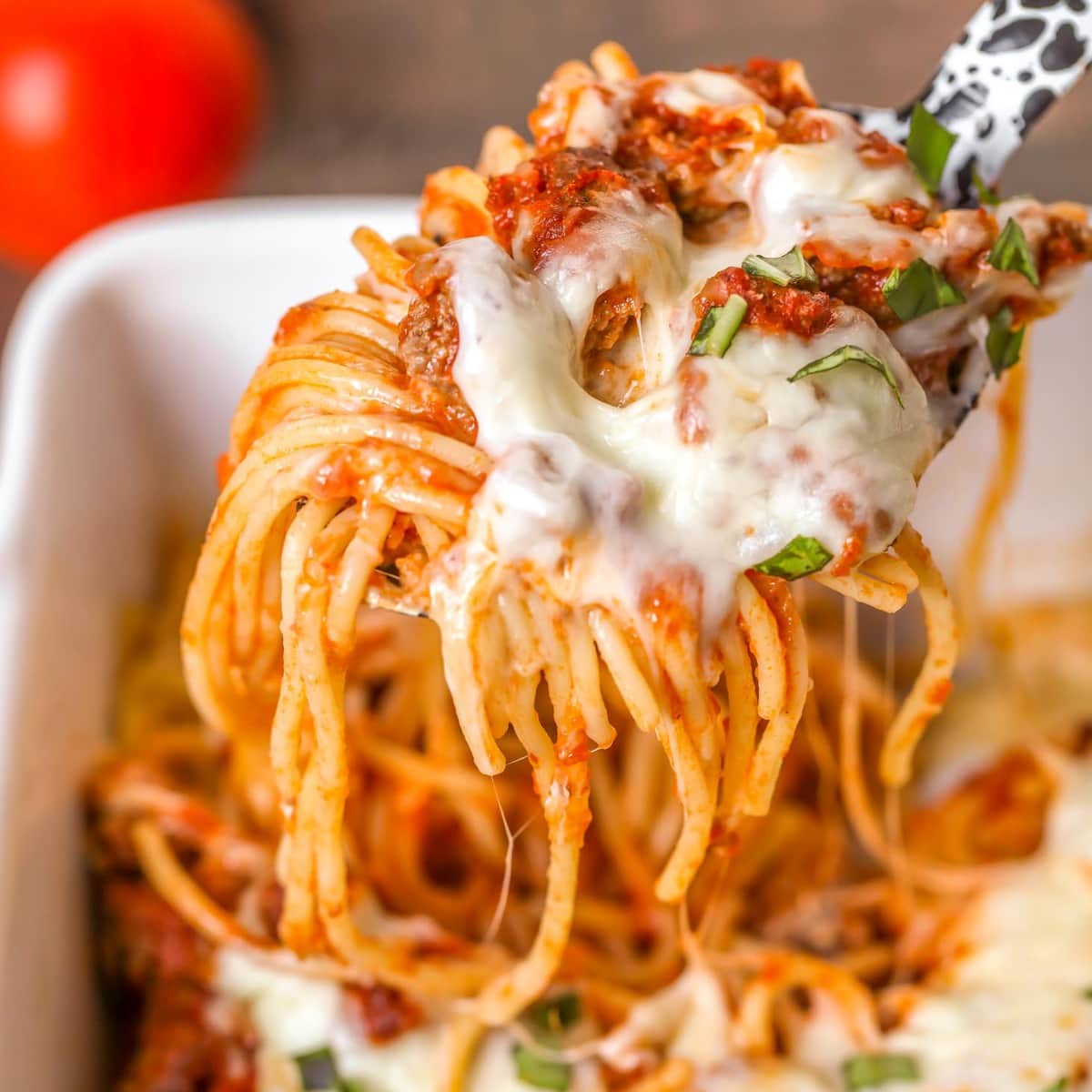 Vegetarian Pasta Recipes - A serving spoon scooping baked spaghetti out of a casserole dish.