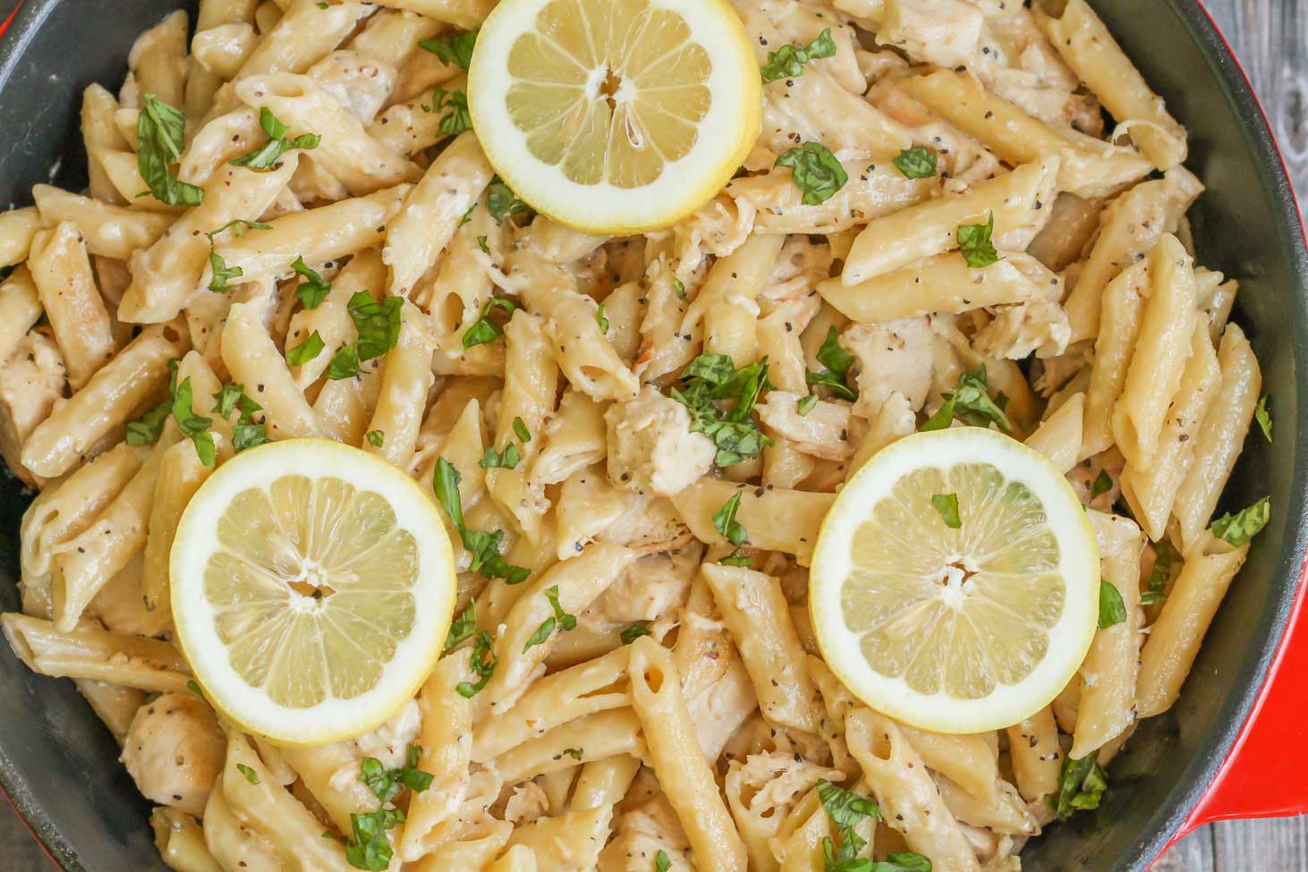 Creamy Lemon Chicken Pasta topped with sliced lemon in a pan