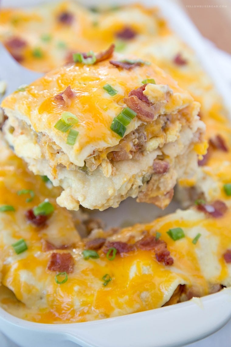 Breakfast casserole recipes - scooping a slice from a baking dish of breakfast enchilada casserole.