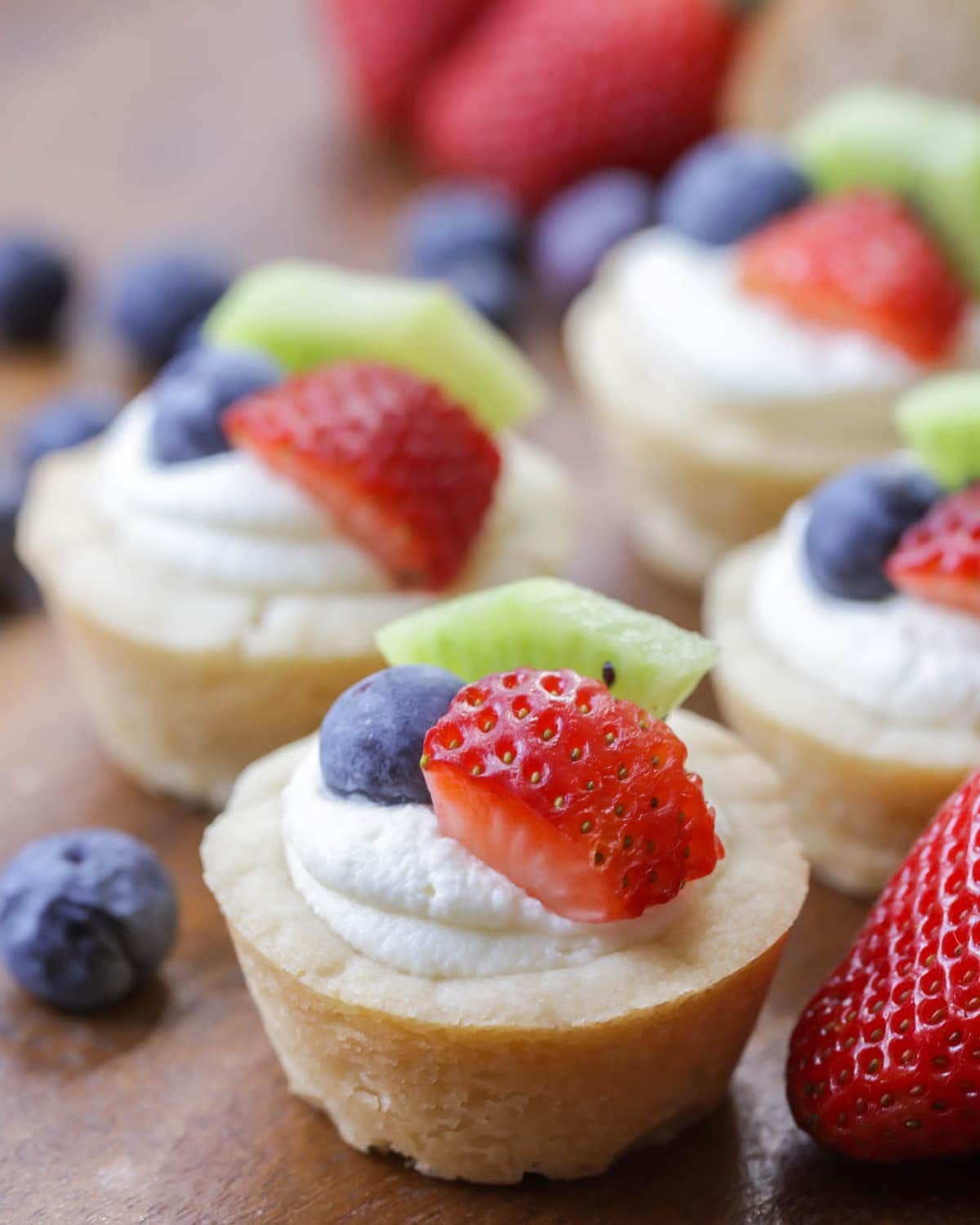 Mini Fruit Tarts topped with cream and fresh berries