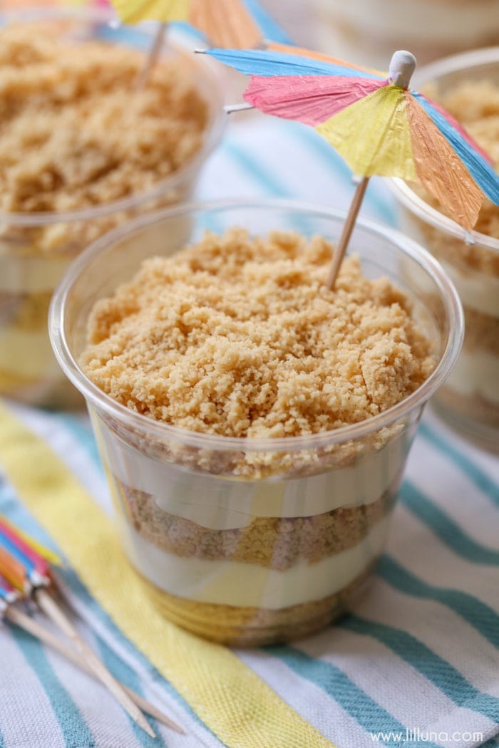 close up of sand pudding cups topped with beach umbrellas