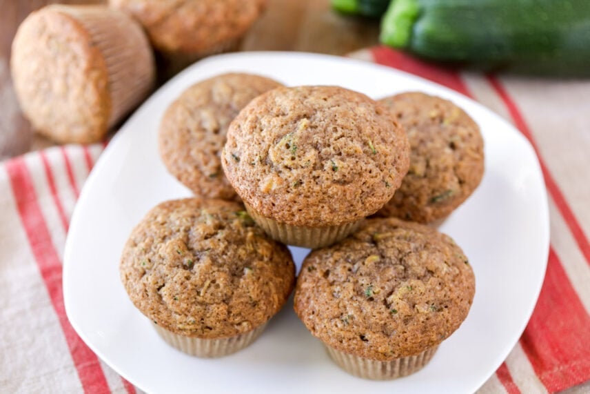 Healthy zucchini muffins stacked on a white plate