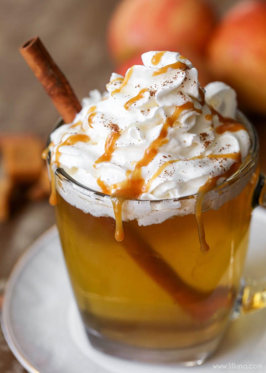 Holiday drink ideas - glass mug of caramel apple cider topped with whipped cream.