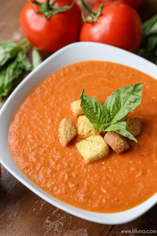 Healthy Soup Recipes - Tomato basil soup in a white bowl topped with croutons.