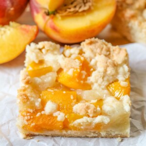 A slice of peach bars on crinkled parchment paper.