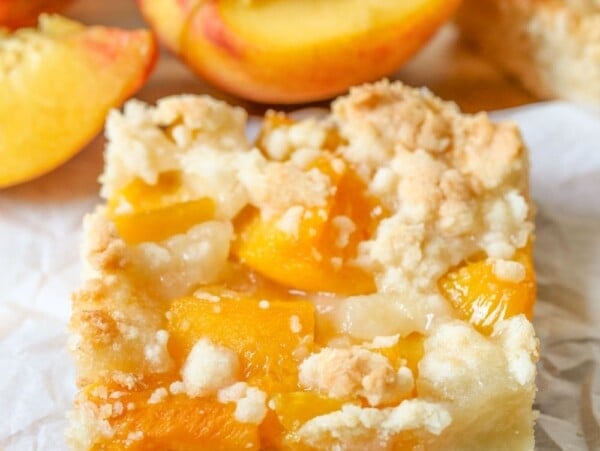 A slice of peach bars on crinkled parchment paper.