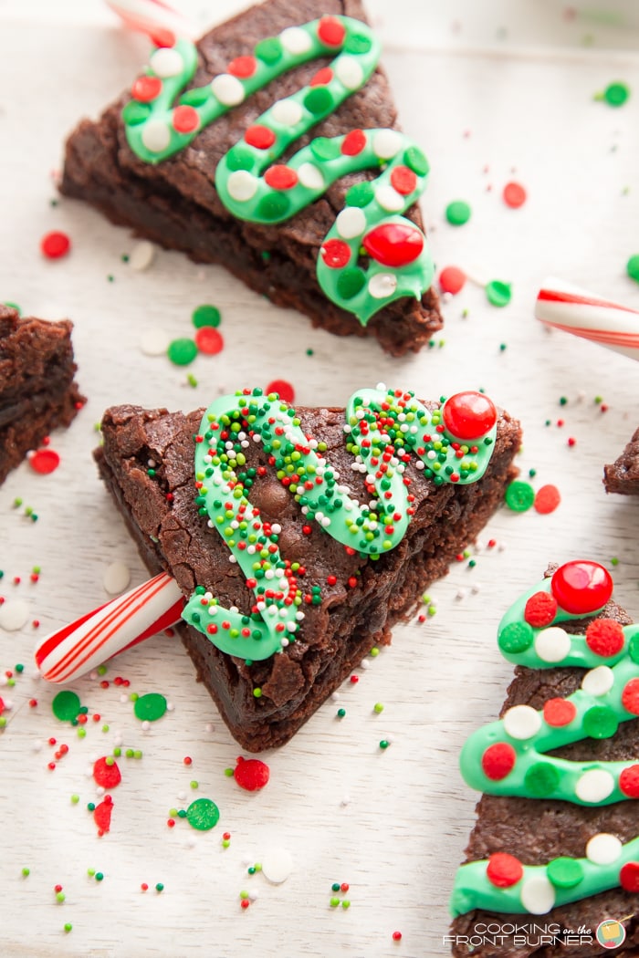 Christmas tree brownies decorated with green frosting and sprinkles.