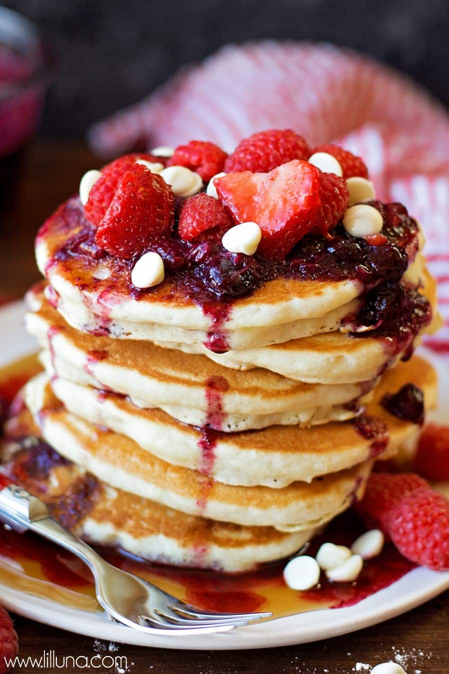 Breakfast for dinner - white chocolate berry pancakes stacked on a plate.