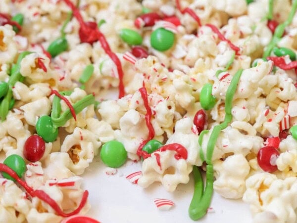 Christmas popcorn drizzled with chocolate and filled with M&Ms and crushed candy canes.