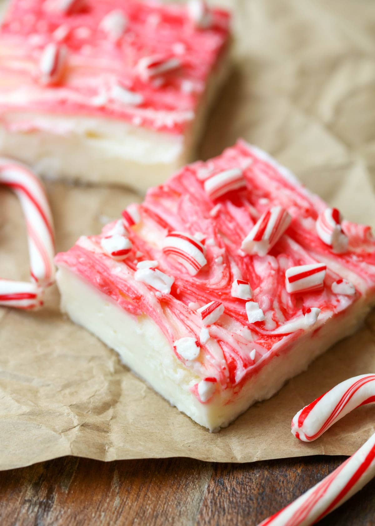 No-bake peppermint cheesecake bars topped with crushed candy cane.