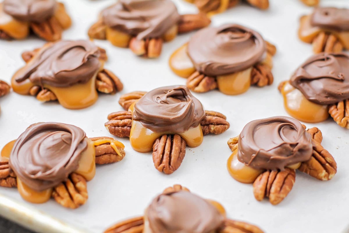 Turtle candy recipe on parchment paper on baking sheet close up image.