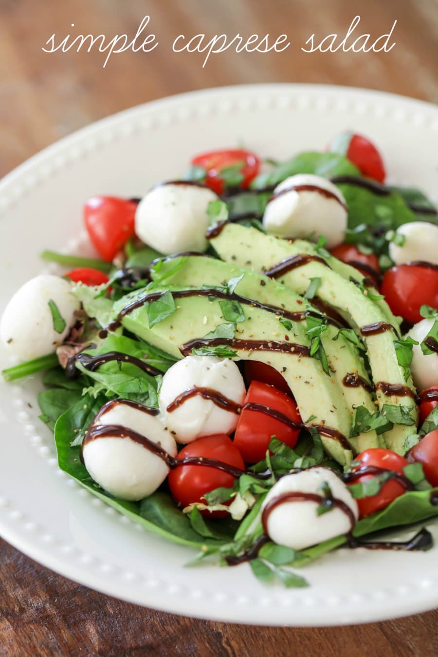Quick and simple Caprese Salad drizzled with balsamic in a white bowl