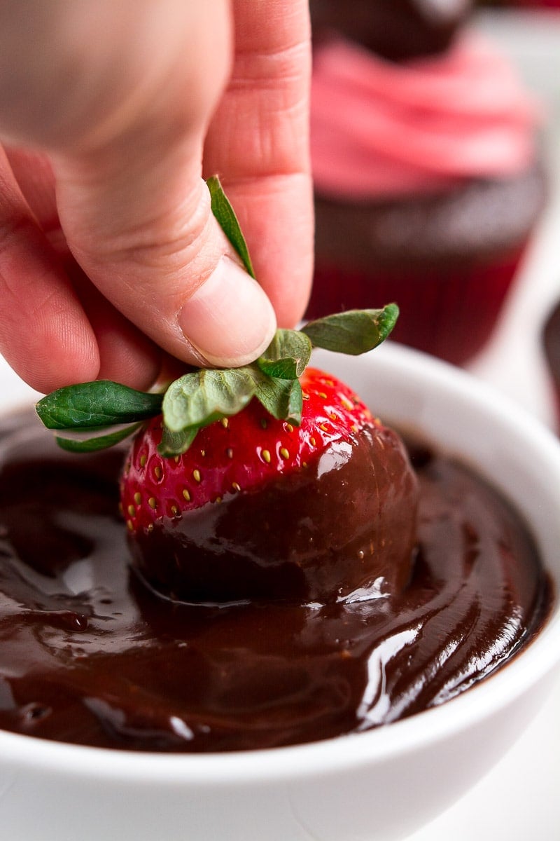 Strawberry being dipped in chocolate in bowl