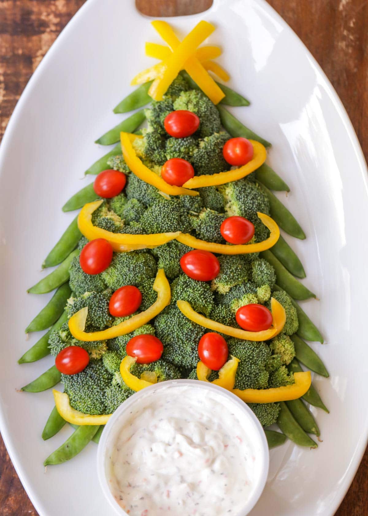 Christmas veggie tray on a white plate served with dip.