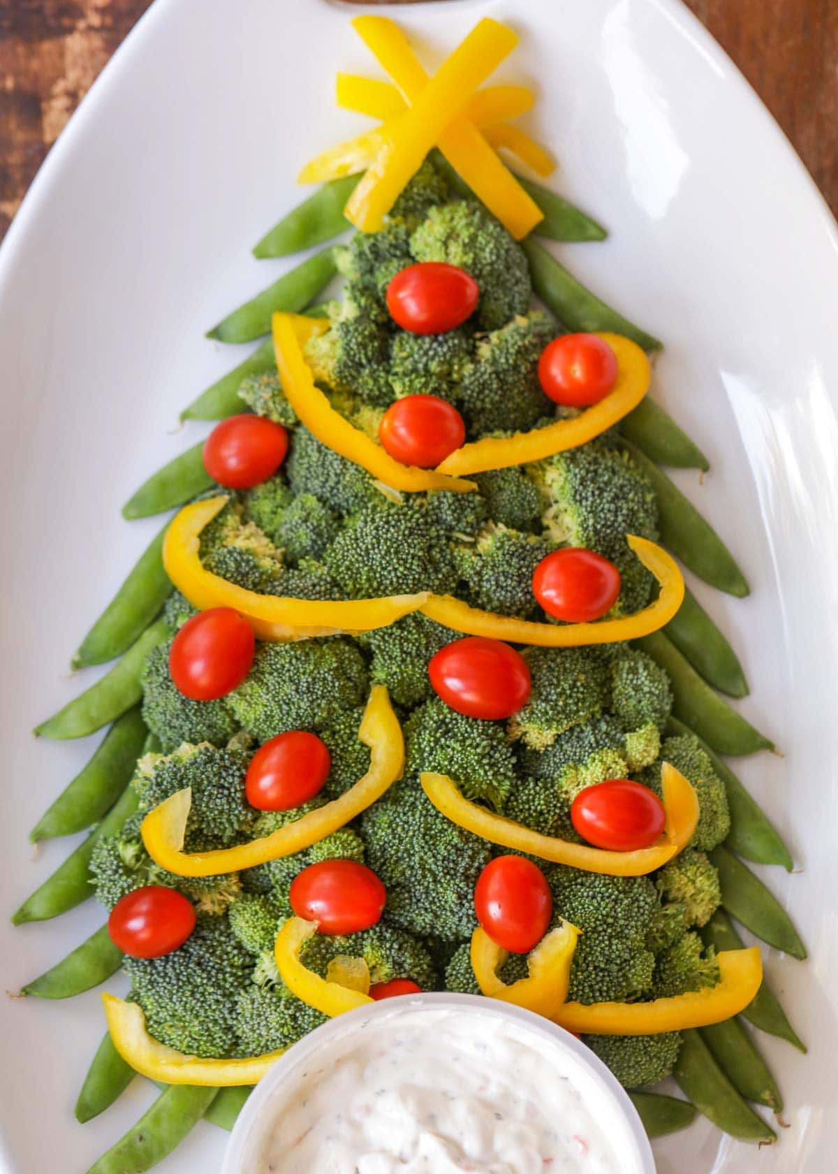 Christmas veggie tray shaped like a tree and served with dip.