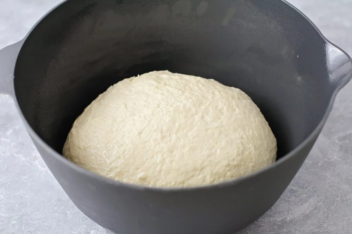 Homemade bread dough in mixing bowl.