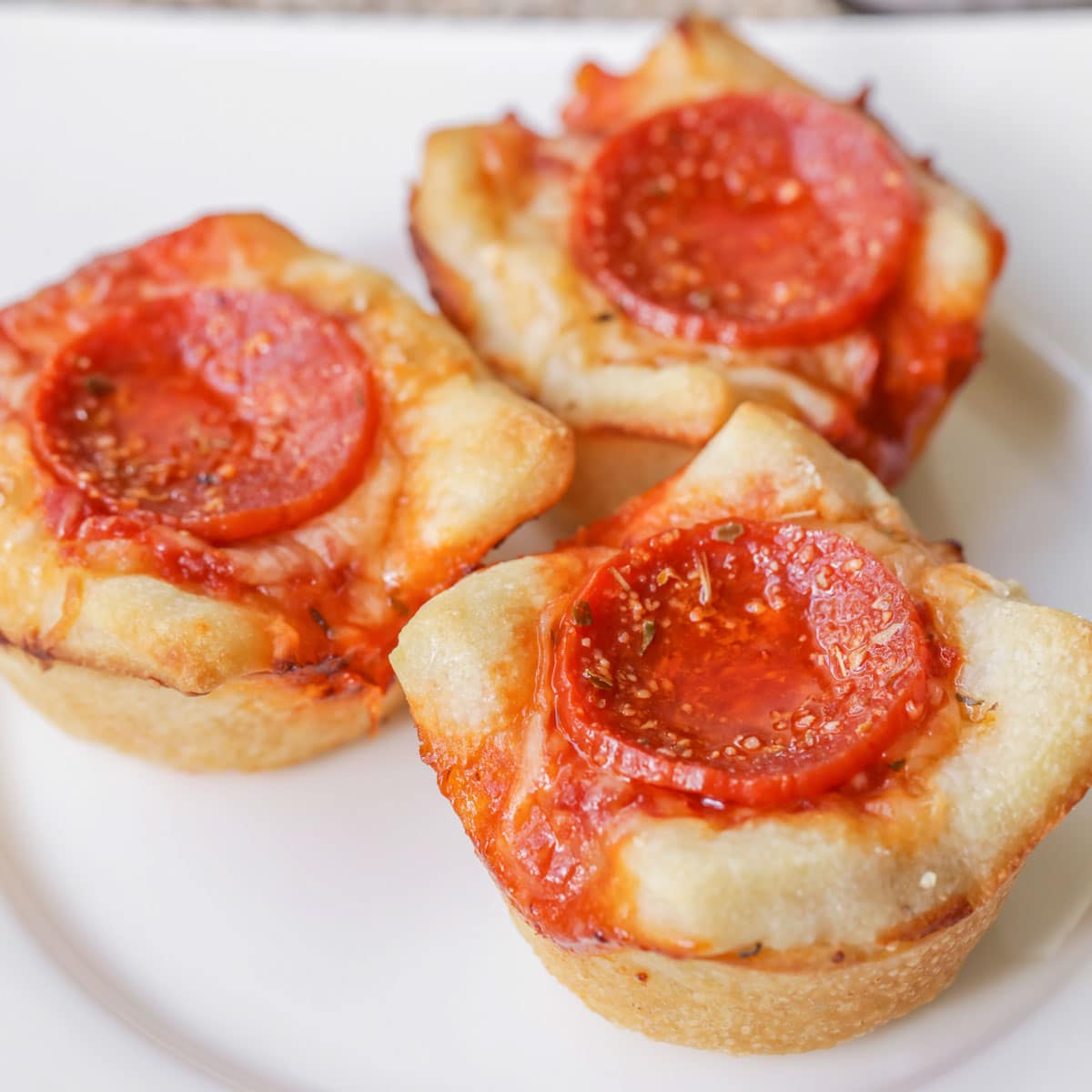 Halloween appetizers - close up of mini deep dish pizzas served on a white plate.