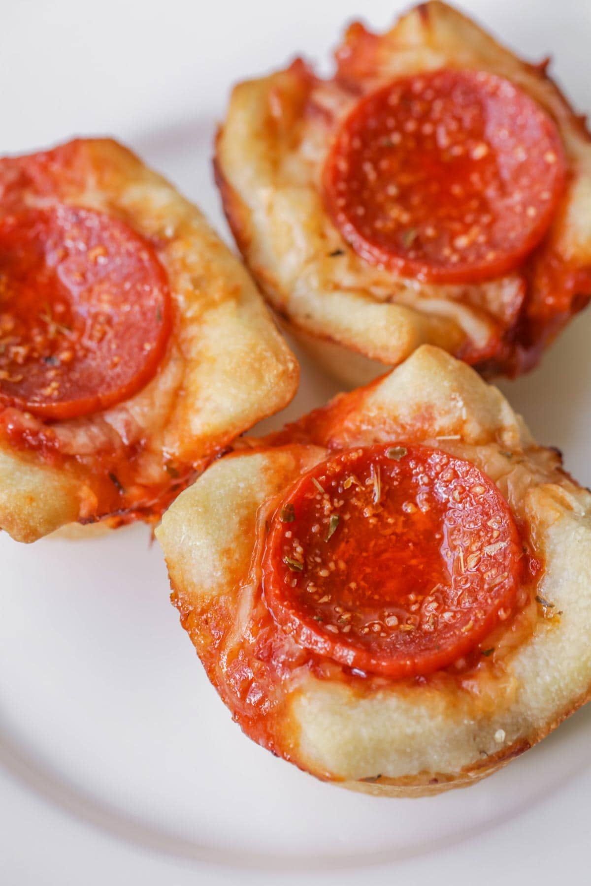 Italian Christmas Dinner ideas - close up of 3 mini deep dish pizzas topped with pepperoni.