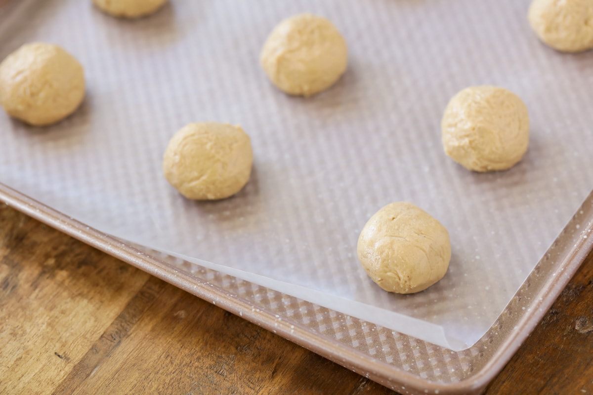 peanut butter balls chilling on a cookie sheet