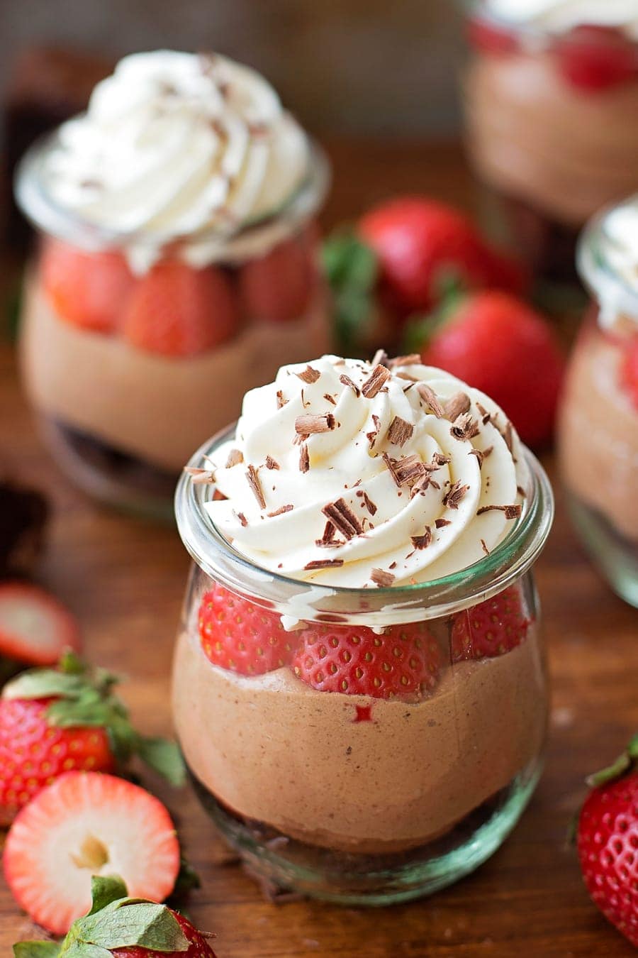 No-Bake Strawberry Nutella Cheesecakes topped with whipped cream and chocolate shavings