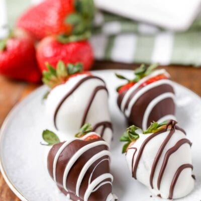 3 chocolate covered strawberries on white plate