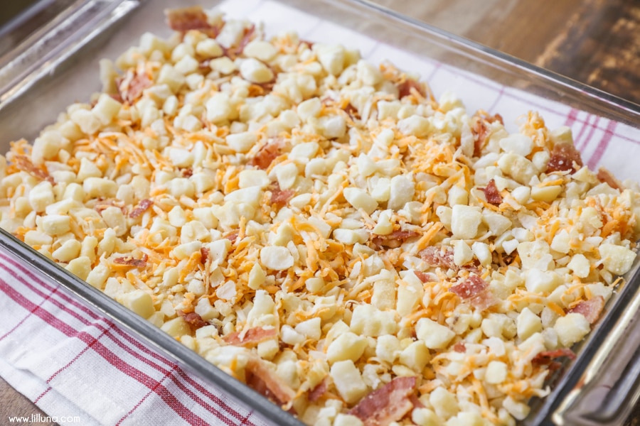 Hashbrowns, cheese, and bacon in a glass baking dish