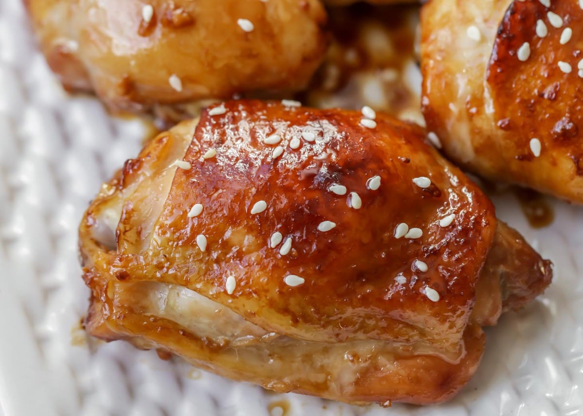 Honey Garlic Chicken Thighs topped with sesame seeds on a baking sheet