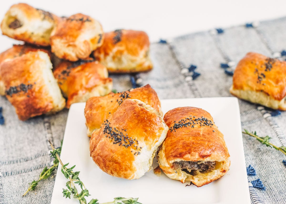 Halloween dinner ideas - sausage rolls piled on a white plate.