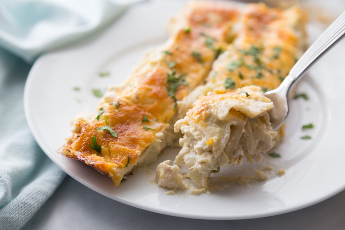 Cream cheese chicken enchiladas on white plate.