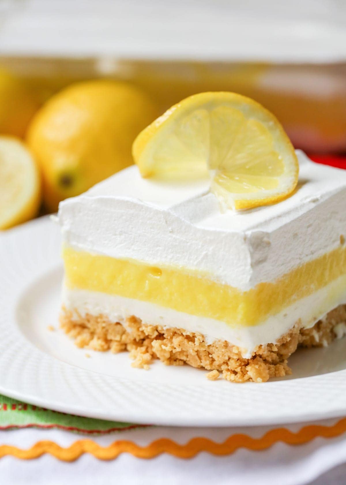 Lemon Lush topped with a lemon slice on a white plate