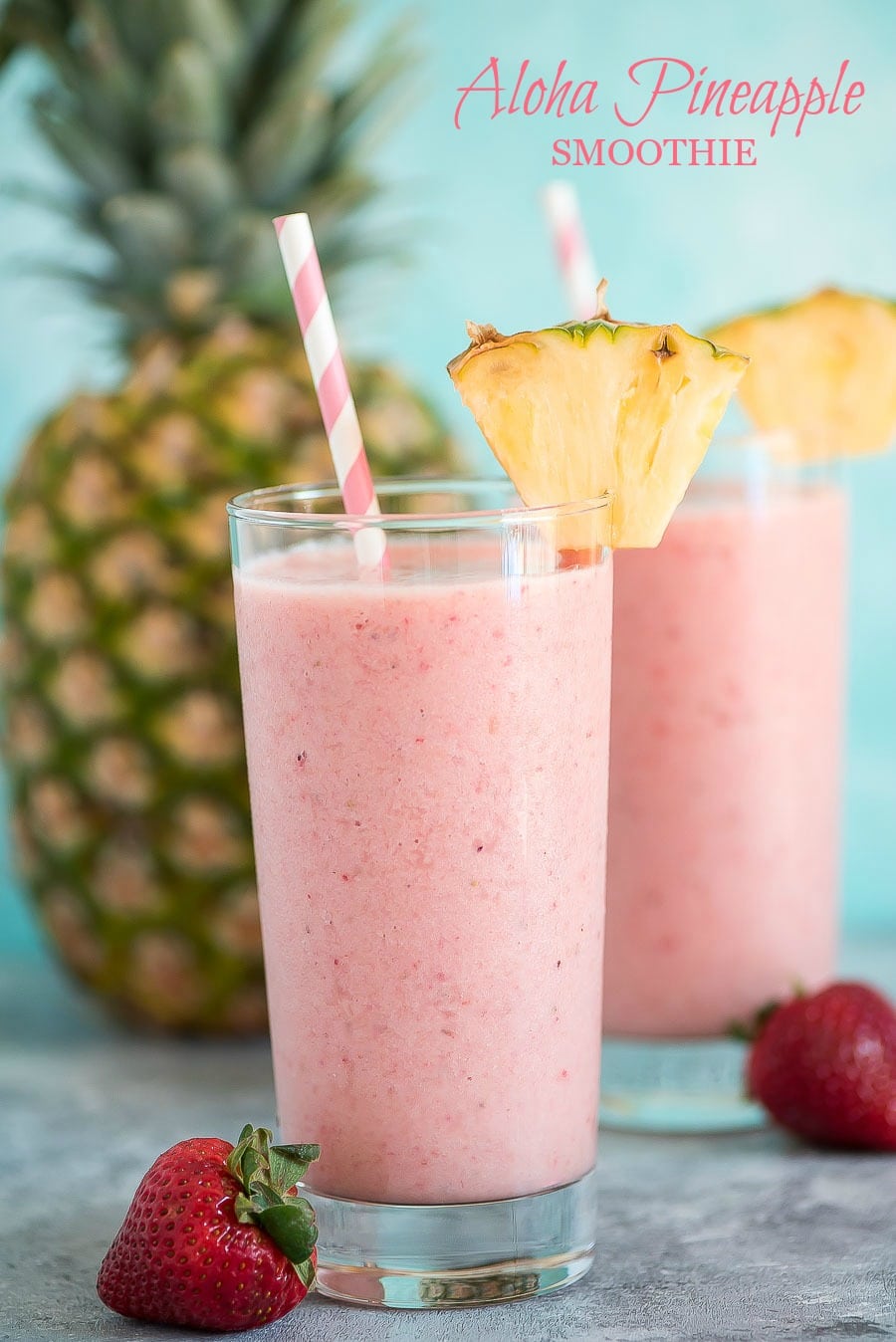 aloha tropical smoothie served in a glass with pineapple and a straw