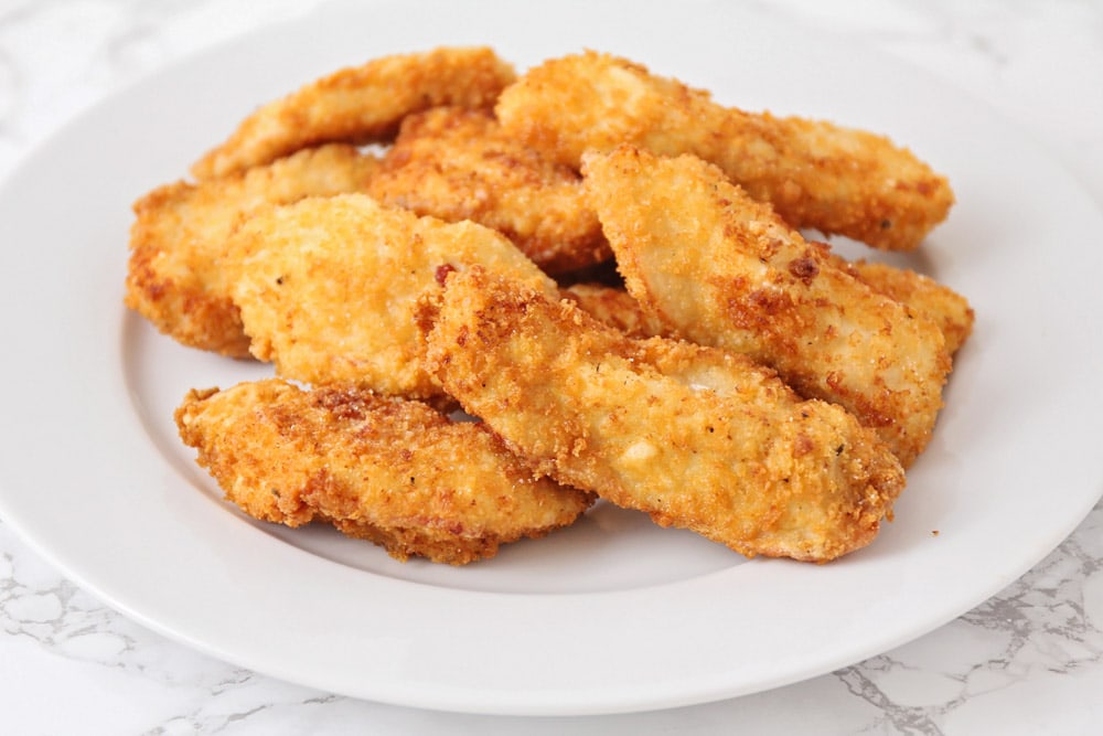 Breaded chicken for Applebee's Oriental salad chicken on a white plate.