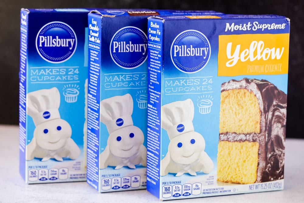 Three boxes of Pillsbury cake mix sitting on a countertop.