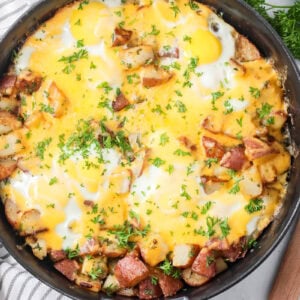 Eggs and Potatoes are hearty, cheesy, and easy to make in one skillet with tender red potatoes, baked eggs, garlic, and cheddar.