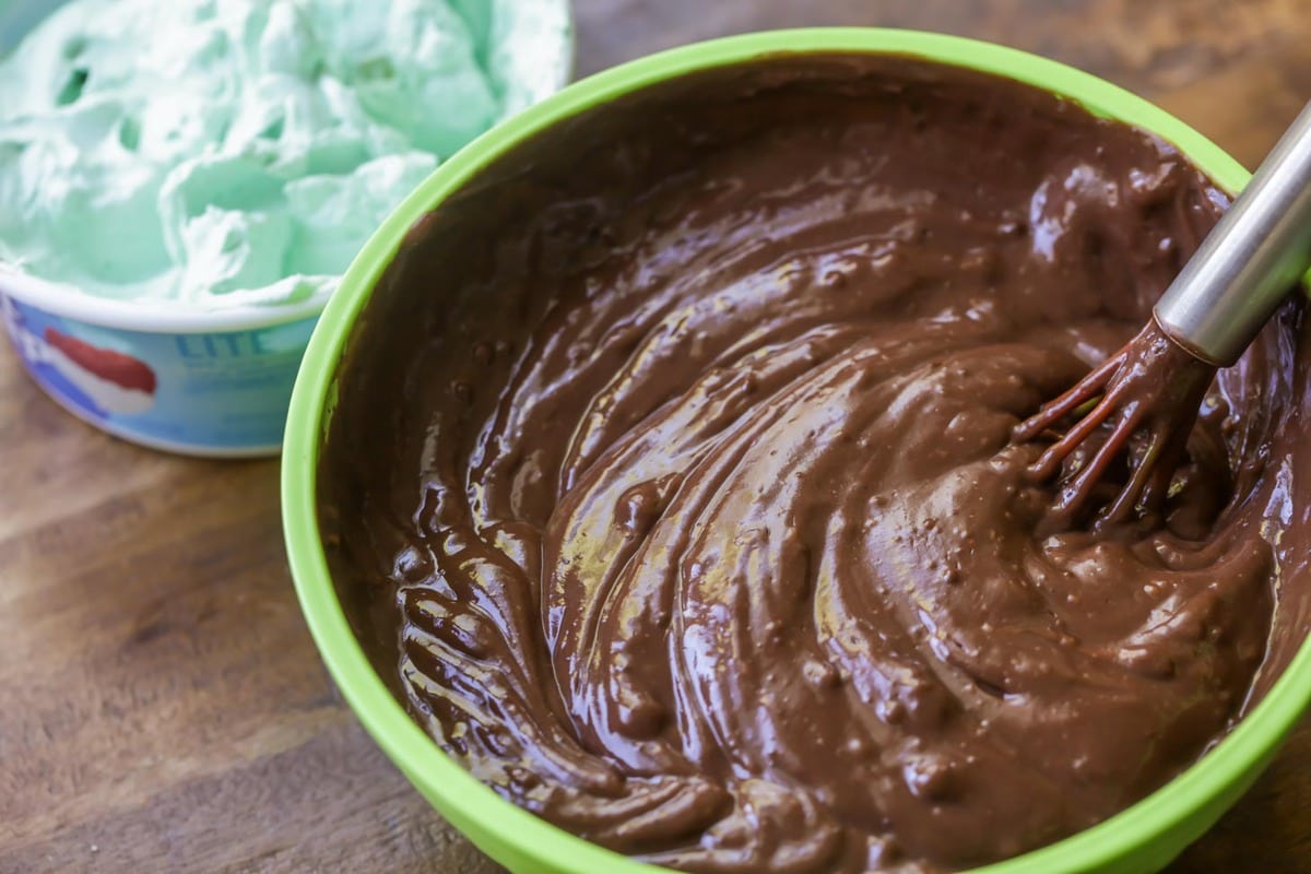 chocolate pudding in a green bowl, and green whipped cream