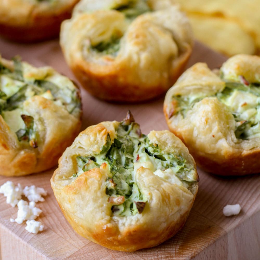 Close up of spinach puffs served on a cutting board.