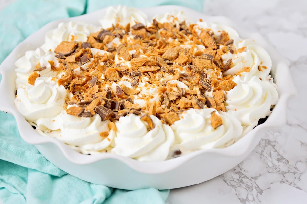 No Bake Butterfinger Pie with whipped cream and crushed butterfinger topping