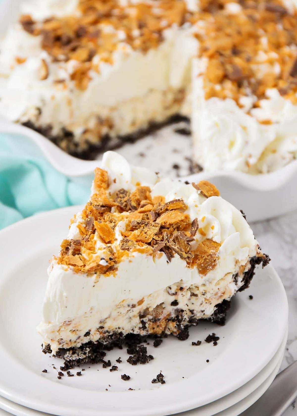 A slice of butterfinger ice cream pie on a white plate