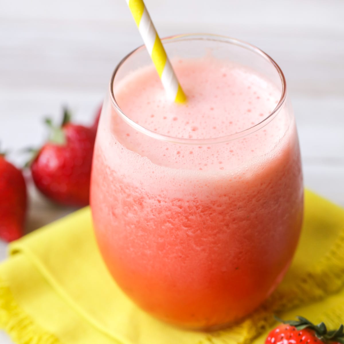 Frozen strawberry lemonade in a glass with a straw.