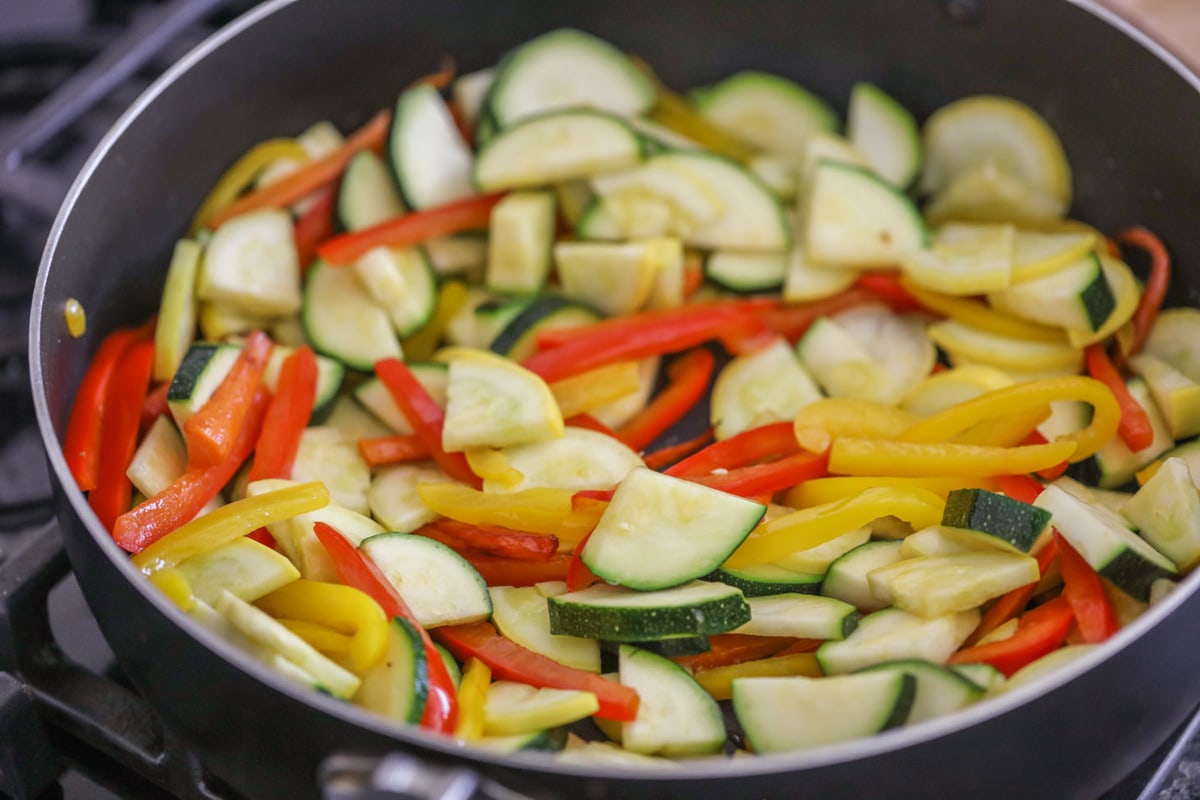 Sautéing vegetables in a frying pan.