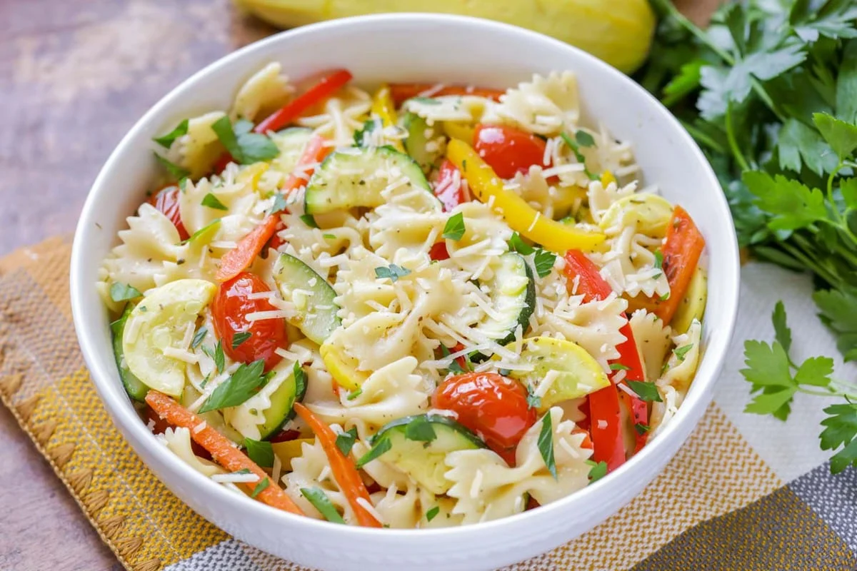 Pasta primavera served in a white bowl.