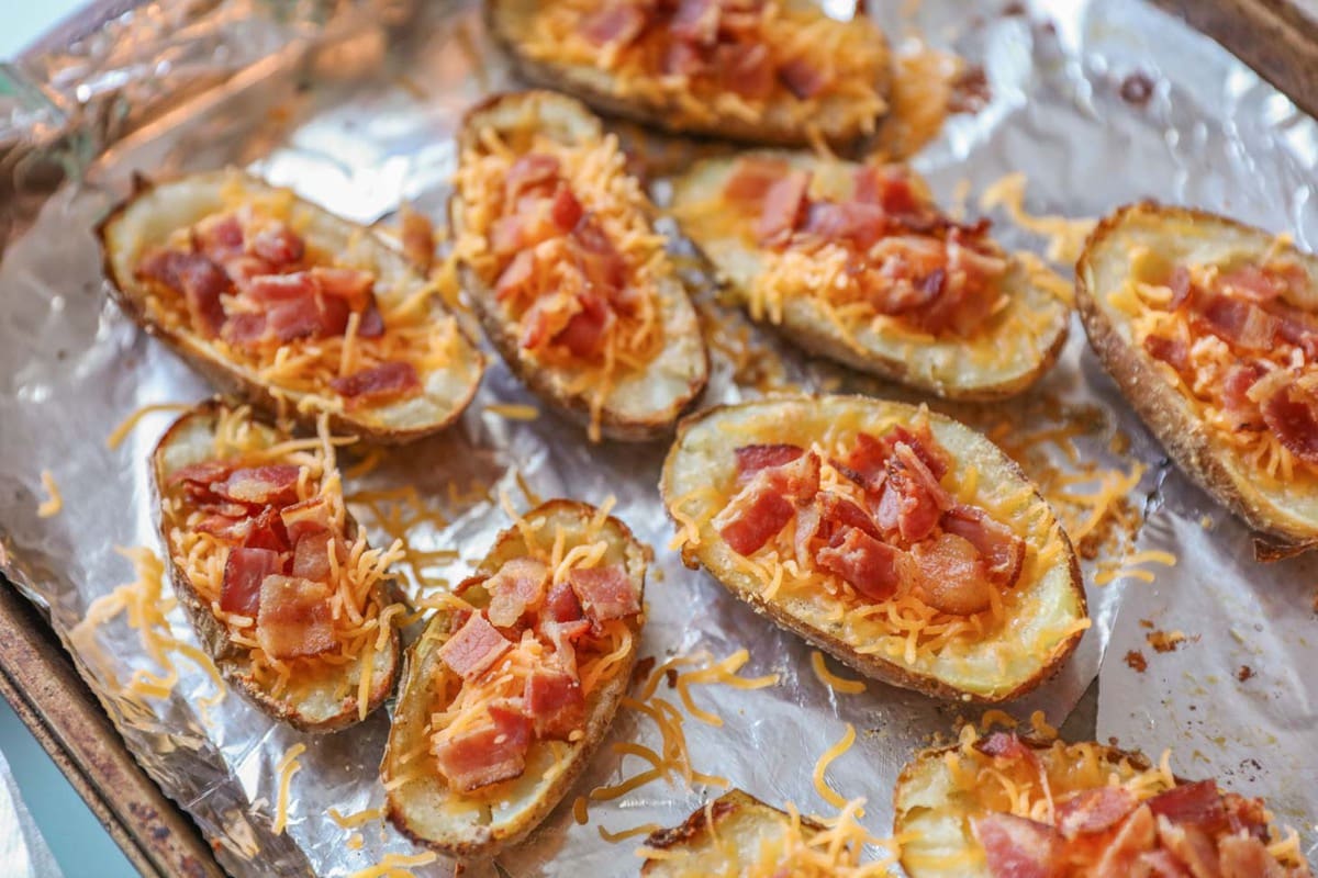 Potato skins filled with bacon and cheese on a sheet pan