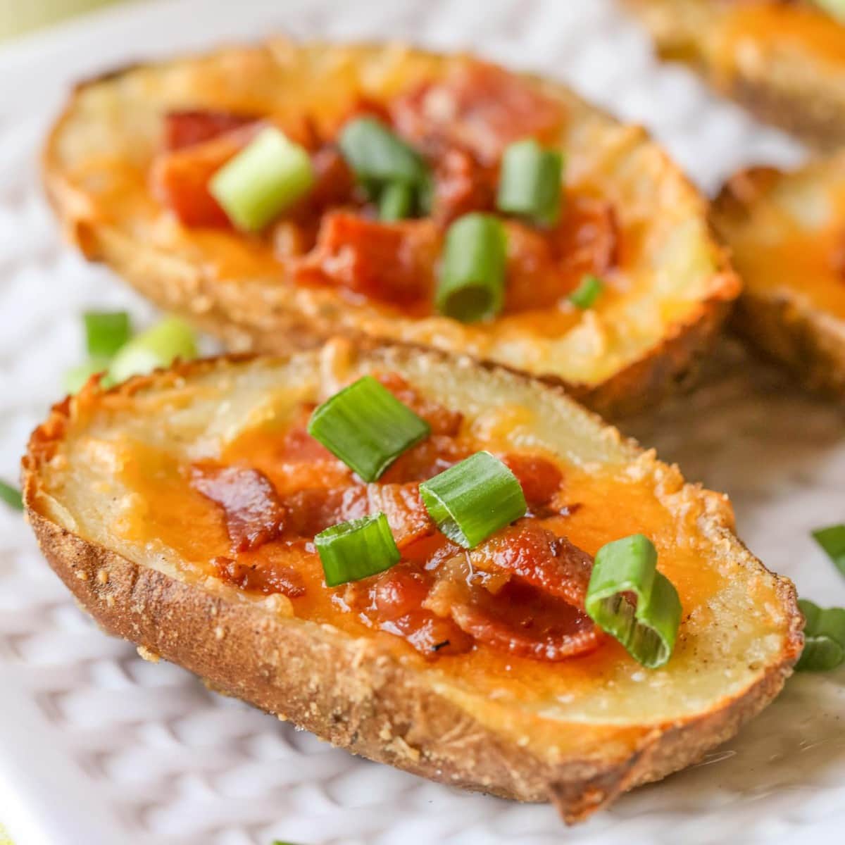 Christmas appetizers -  close up of parmesan crusted potato skins loaded with bacon and green onions.