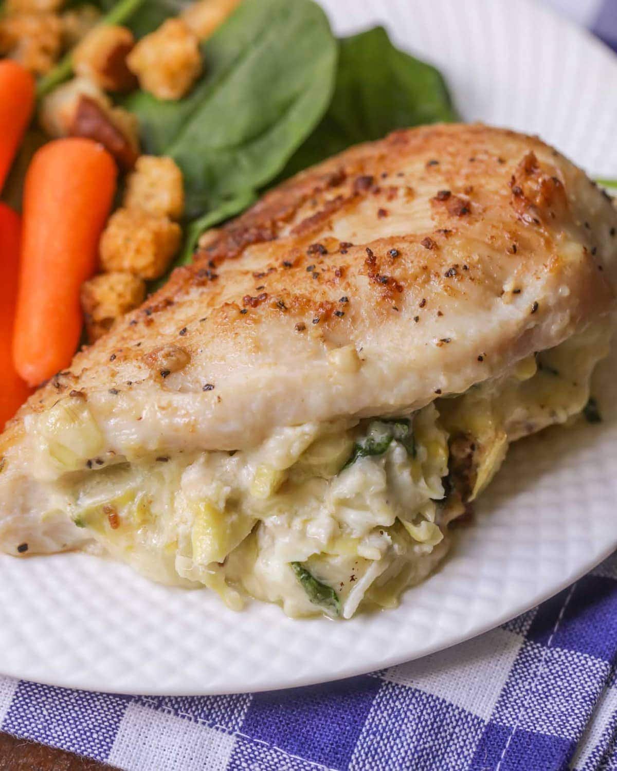 Spinach Artichoke Stuffed Chicken on a plate with salad