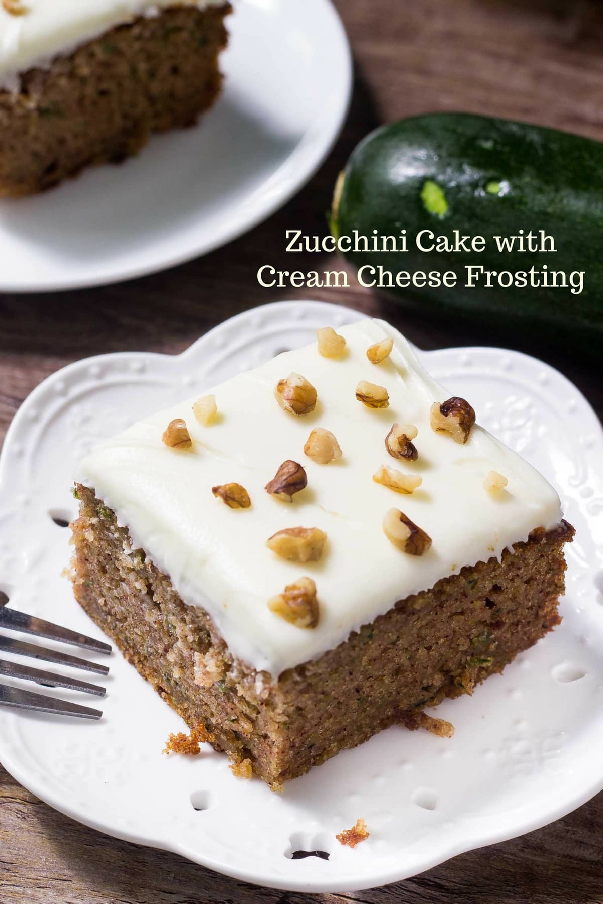 Zucchini cake topped with frosting and walnuts