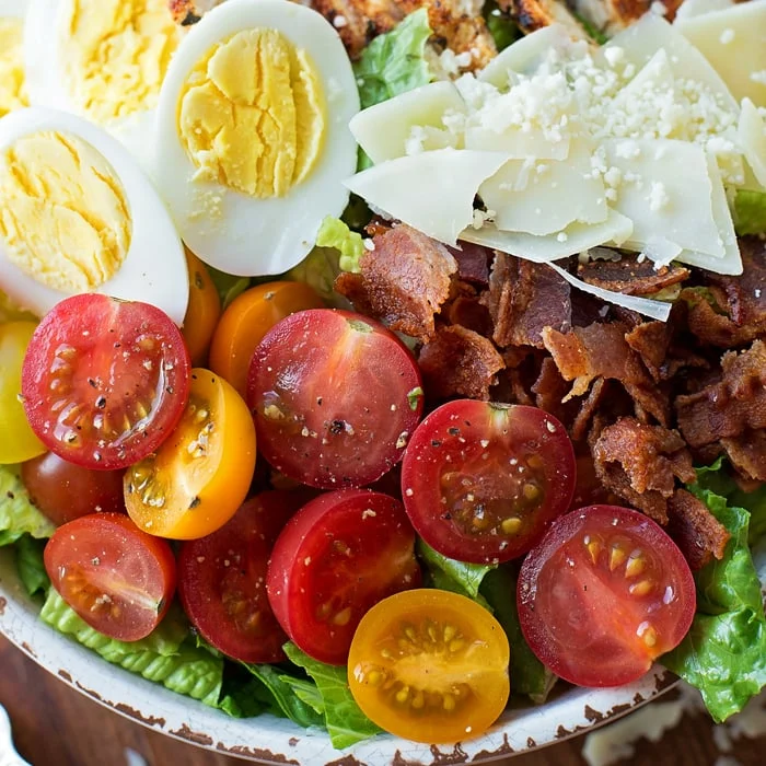 Close up of tomatoes and hard boiled eggs on a salad.