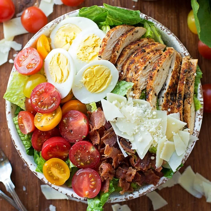 Chicken Caesar Salad with tomatoes, eggs, bacon, cheese and more.