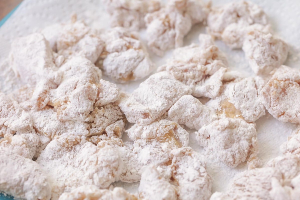 Pieces of chicken coated in flour for general tso chicken recipe